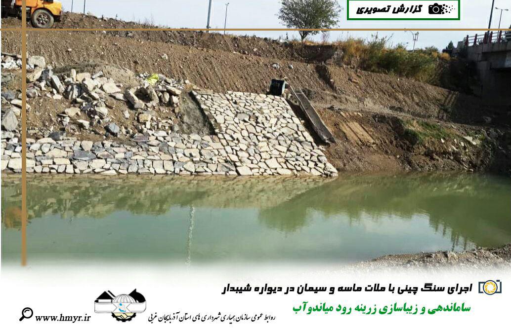 گزارش تصویری از ساماندهی و زیباسازی زرینه رود میاندوآب  اجرای لایه های خاکریزی در مسیر برم دوم - اجرای سنگ چینی با ملات ماسه و سیمان در دیواره شیبدار
